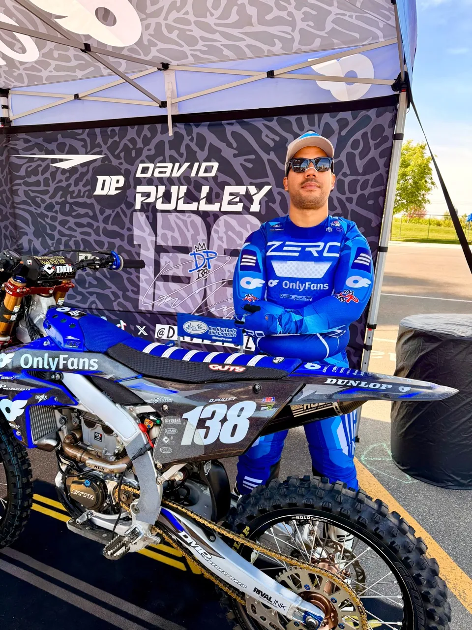 David Pulley Jr. standing with his number 138 bike in the paddock